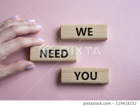 We need you symbol. Concept words We need you on wooden blocks. Beautiful pink background. Businessman hand. Business and We need you concept. Copy space. 119418152