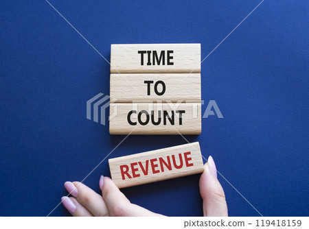 Time to count Revenue symbol. Wooden blocks with words Time to count Revenue. Beautiful deep blue background. Businessman hand. Business and Time to count Revenue concept. Copy space. 119418159