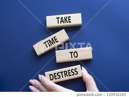 Take time to Destress symbol. Wooden blocks with words Take time to Destress. Beautiful deep blue background. Businessman hand. Business and Take time to Destress concept. Copy space. 119418165