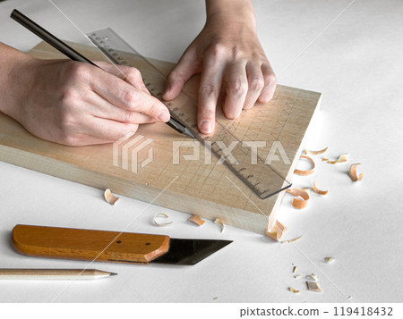 Hands crafting wood with precision. Marking and measuring techniques Hands crafting wood with precision. Marking and measuring techniques 119418432
