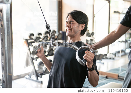 An Asian man and his trainer who push and improve their skills with one-on-one instruction at a gym/personal gym 119419160
