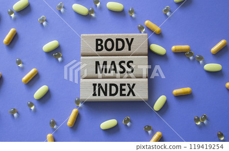 Body Mass Index symbol. Concept word Body Mass Index on wooden blocks. Beautiful purple background with pills. Medicine and Body Mass Index concept. Copy space Body Mass Index symbol. Concept word Body Mass Index on wooden blocks. Beautiful purple background with pills. Medicine and Body Mass Index concept. Copy space 119419254