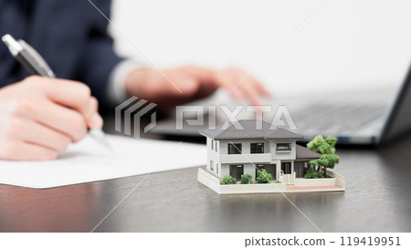 Hands of a businessman creating real estate documents Hands of a businessman creating real estate documents 119419951