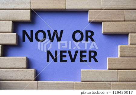 Now or Never symbol. Concept words Now or Never on wooden blocks. Beautiful purple background. Business and Now or Never concept. Copy space Now or Never symbol. Concept words Now or Never on wooden blocks. Beautiful purple background. Business and Now or Never concept. Copy space 119420017