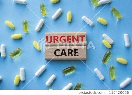 Urgent Care symbol. Concept word Urgent Care on wooden blocks. Beautiful blue background with pills. Medicine and Urgent Care concept. Copy space Urgent Care symbol. Concept word Urgent Care on wooden blocks. Beautiful blue background with pills. Medicine and Urgent Care concept. Copy space 119420066