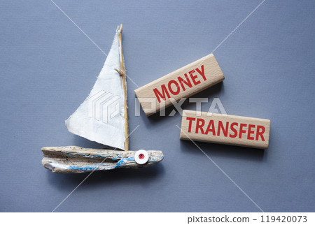 Money Transfer symbol. Concept word Money Transfer on wooden blocks. Beautiful grey background with boat. Business and Money Transfer concept. Copy space Money Transfer symbol. Concept word Money Transfer on wooden blocks. Beautiful grey background with boat. Business and Money Transfer concept. Copy space 119420073