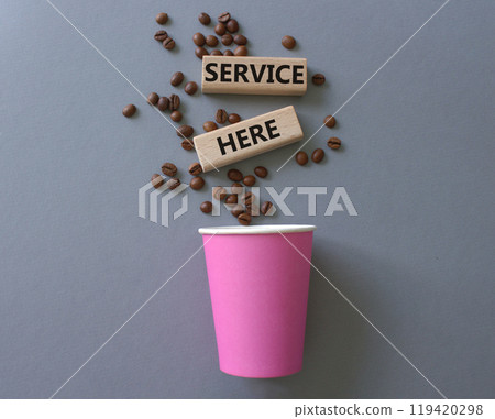 Service here symbol. Concept words Service here on wooden blocks. Beautiful grey background with coffee shop and coffee beans. Business and Service here concept. Copy space. 119420298