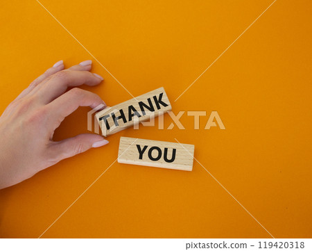 Thank you symbol. Wooden blocks with words Thank you. Businessman hand. Beautiful orange background. Business and Thank you concept. Copy space. Thank you symbol. Wooden blocks with words Thank you. Businessman hand. Beautiful orange background. Business and Thank you concept. Copy space. 119420318