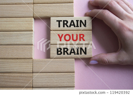 Train Your Brain symbol. Concept words Train Your Brain on wooden blocks. Beautiful pink background. Doctor hand. Healthcare and Train Your Brain concept. Copy space. Train Your Brain symbol. Concept words Train Your Brain on wooden blocks. Beautiful pink background. Doctor hand. Healthcare and Train Your Brain concept. Copy space. 119420392