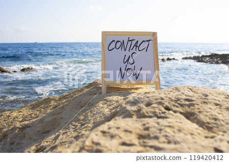 Contact us now symbol. White Blackboard with words Contact us now. Beautiful sea background. Business and Contact us now concept. Copy space. Contact us now symbol. White Blackboard with words Contact us now. Beautiful sea background. Business and Contact us now concept. Copy space. 119420412