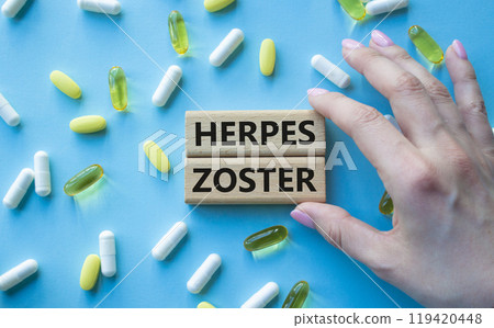 Herpes Zoster symbol. Concept word Herpes Zoster on wooden blocks. Beautiful blue background with pills. Doctor Hand. Medicine and Herpes Zoster concept. Copy space Herpes Zoster symbol. Concept word Herpes Zoster on wooden blocks. Beautiful blue background with pills. Doctor Hand. Medicine and Herpes Zoster concept. Copy space 119420448