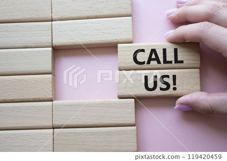 Call Us symbol. Wooden blocks with words Call Us. Businessman hand. Beautiful pink background. Business and Call Us concept. Copy space. 119420459