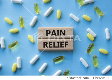 Pain Relief symbol. Concept word Pain Relief on wooden blocks. Beautiful blue background with pills. Medicine and Pain Relief concept. Copy space 119420502
