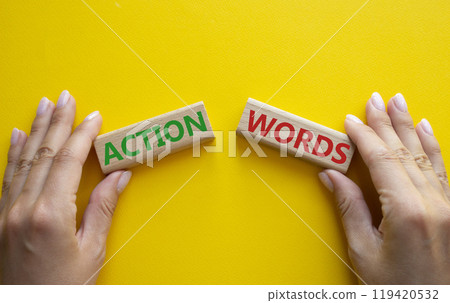 Action or words symbol. Concept word Action or words on wooden blocks. Businessman hand. Beautiful yellow background. Business and Action or words concept. Copy space Action or words symbol. Concept word Action or words on wooden blocks. Businessman hand. Beautiful yellow background. Business and Action or words concept. Copy space 119420532