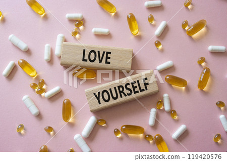 Love Yourself symbol. Concept words Love Yourself on wooden blocks. Beautiful pink background with pills. Mindfulness and Love Yourself concept. Copy space. Love Yourself symbol. Concept words Love Yourself on wooden blocks. Beautiful pink background with pills. Mindfulness and Love Yourself concept. Copy space. 119420576