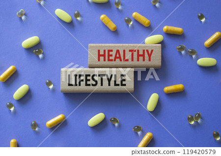 Healthy Lifestyle symbol. Concept words Healthy Lifestyle on wooden blocks. Beautiful purple background with pills. Medicine and Healthy Lifestyle concept. Copy space. 119420579