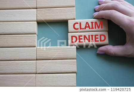 Claim denied symbol. Wooden blocks with words Claim denied. Businessman hand. Beautiful grey green background. Business and Claim denied concept. Copy space. Claim denied symbol. Wooden blocks with words Claim denied. Businessman hand. Beautiful grey green background. Business and Claim denied concept. Copy space. 119420725