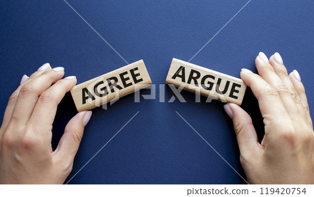 Agree or Argue symbol. Concept word Agree or Argue on wooden blocks. Businessman hand. Beautiful deep blue background. Gender and Agree or Argue concept. Copy space Agree or Argue symbol. Concept word Agree or Argue on wooden blocks. Businessman hand. Beautiful deep blue background. Gender and Agree or Argue concept. Copy space 119420754