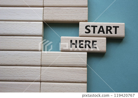 Start here symbol. Wooden blocks with words Start here Beautiful grey green background. Business and Start here concept. Copy space. 119420767