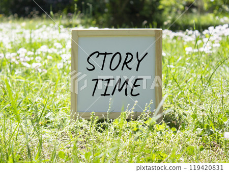 Story Time symbol. Concept word Story Time on white chalk background. Beautiful meadow background. Business and Story Time concept. Copy space 119420831