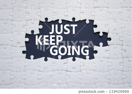 Just keep going symbol. White puzzle with words Just keep going. Beautiful deep blue background. Business and Just keep going concept. Copy space. 119420989
