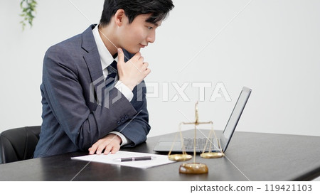 Businessman doing research on a computer Businessman doing research on a computer 119421103