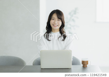 A woman using a computer in the living room 119421549