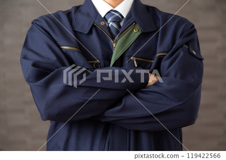 A middle-aged male businessman in work clothes with his arms folded 119422566