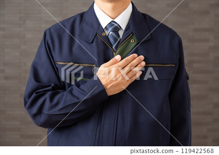 A middle-aged male businessman in work clothes holding his hand on his chest A middle-aged male businessman in work clothes holding his hand on his chest 119422568