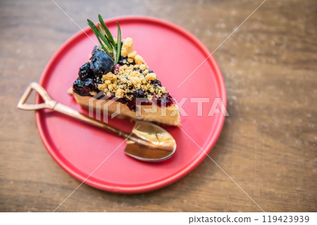 Top view of blueberry cheesecake on red dish over wooden table 119423939