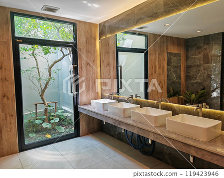 toilet interior design with many sinks by window and outdoor tree 119423946