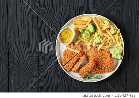breaded pork cutlet with fries, broccoli on plate 119424452