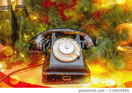 Vintage retro telephone with disk and handset under Christmas tree. New Year's Eve Vintage retro telephone with disk and handset under Christmas tree. New Year's Eve 119424889