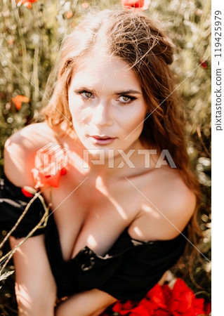 Woman poppies field. portrait happy woman with long hair in a poppy field and enjoying the beauty of nature in a warm summer day. 119425979