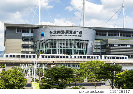 A train on the Wenhu or Brown Line of the Taipei MRT, Taiwan passes by the Taipei Nangang Exhibition Center Hall 1. A train on the Wenhu or Brown Line of the Taipei MRT, Taiwan passes by the Taipei Nangang Exhibition Center Hall 1. 119426117