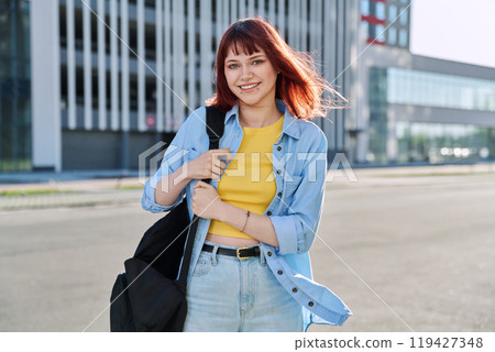 Portrait of young smiling female college student with backpack, city background Portrait of young smiling female college student with backpack, city background 119427348