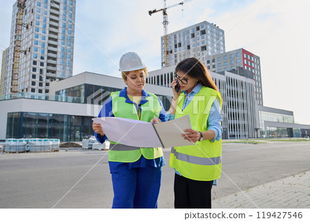 Two confident women talking working on construction of residential office building Two confident women talking working on construction of residential office building 119427546