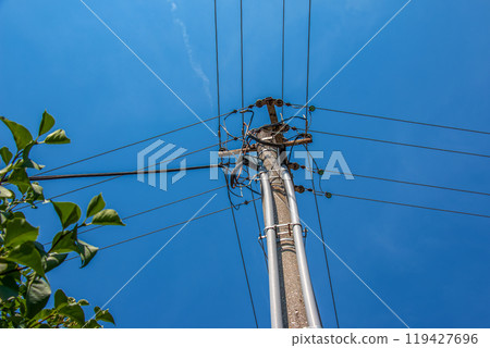 Electric pole power lines outgoing electric wires againts on cloud blue sky. Electric pole power lines outgoing electric wires againts on cloud blue sky. 119427696