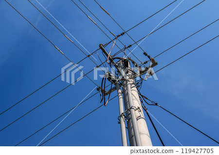 Electric pole power lines outgoing electric wires againts on cloud blue sky. 119427705
