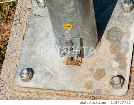 Power pole support. Fastening the base of the support with bolts. Power pole support. Fastening the base of the support with bolts. 119427732