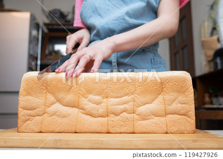 A woman's hands cutting bread 119427926