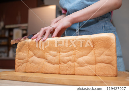 A woman's hands cutting bread 119427927