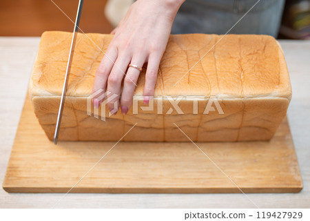 A woman's hands cutting bread 119427929