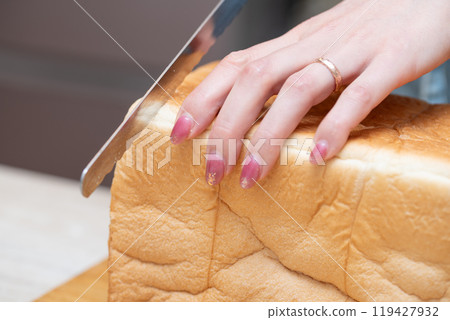 A woman's hands cutting bread 119427932