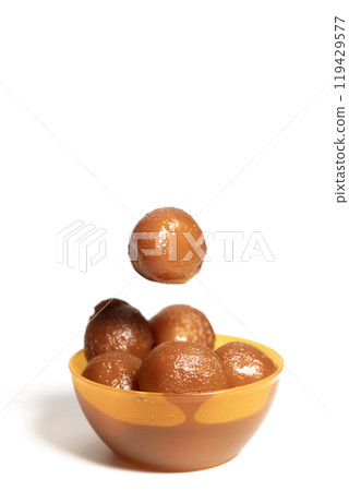 Delicious Gulab Jamun sweets in a vibrant orange bowl on a white background 119429577