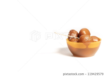 Delicious gulab jamun dessert in orange bowl with wooden spoon. Indian sweets in a bowl with copy space Delicious gulab jamun dessert in orange bowl with wooden spoon. Indian sweets in a bowl with copy space 119429579