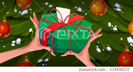 Female hands holding gift box, Christmas tree 119430237