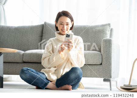 Woman operating a smartphone Woman operating a smartphone 119432248