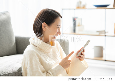Woman operating a smartphone Woman operating a smartphone 119432253