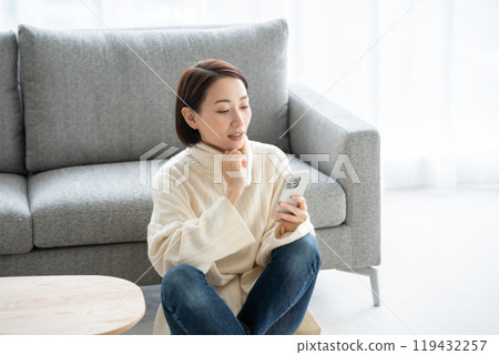 Woman operating a smartphone Woman operating a smartphone 119432257